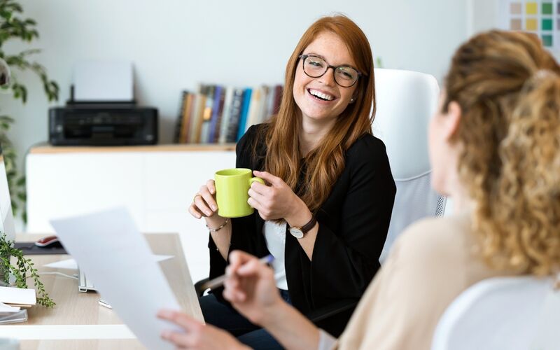 Zwei Frauen bei der Karriereberatung lachen im Gespräch